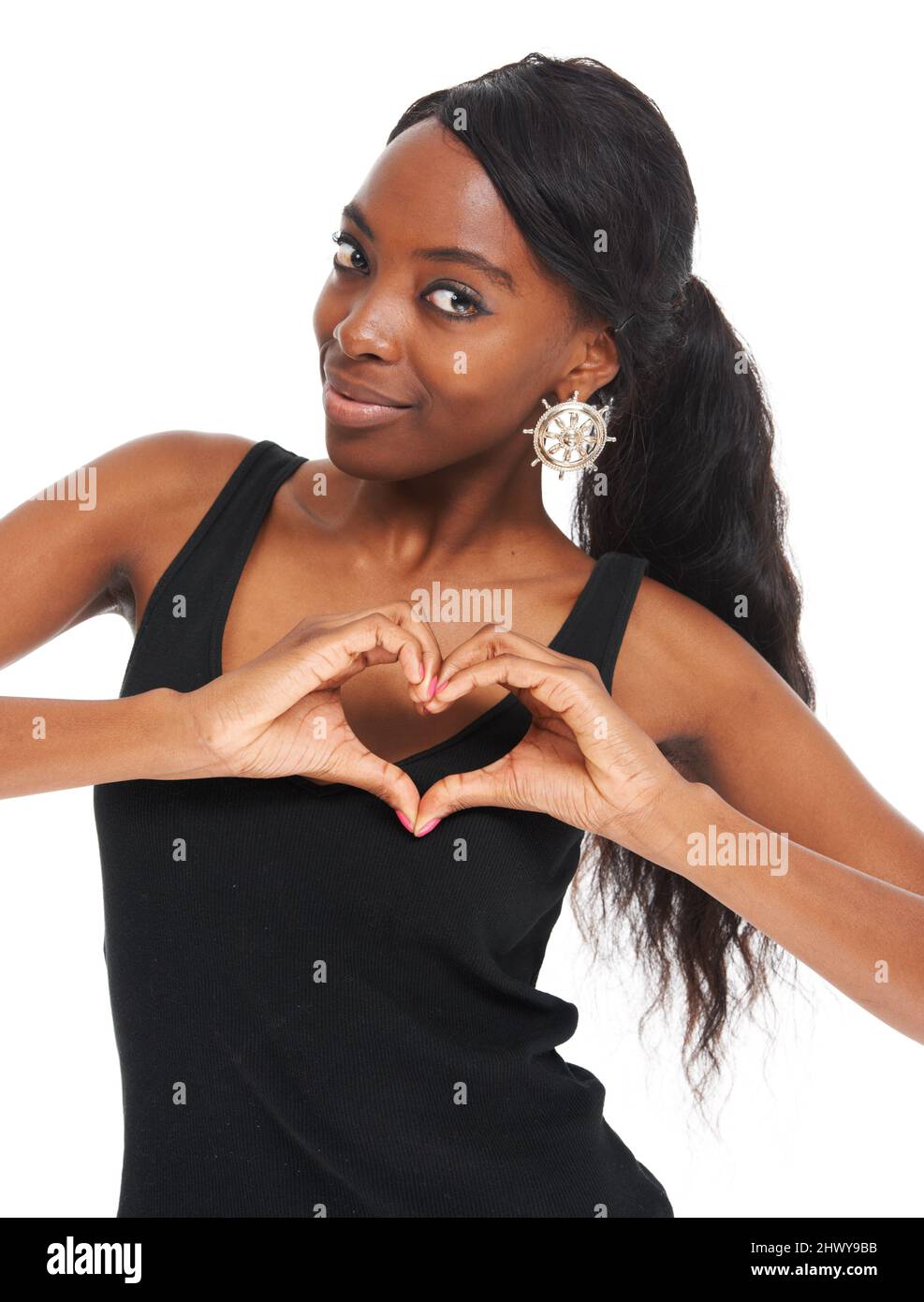 So dove giace il mio cuore. Giovane donna carina che fa una forma di cuore con le dita e sorridente - isolato su bianco. Foto Stock