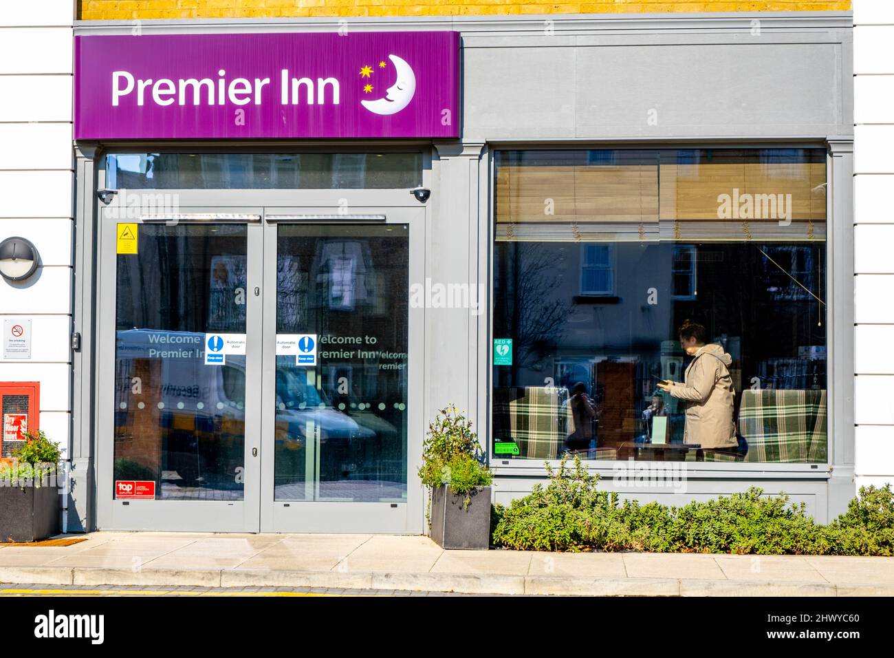 Epsom Surrey London UK, marzo 8 2022, ingresso del moderno Premier Inn Hotel con Customer Standing nella finestra Foto Stock