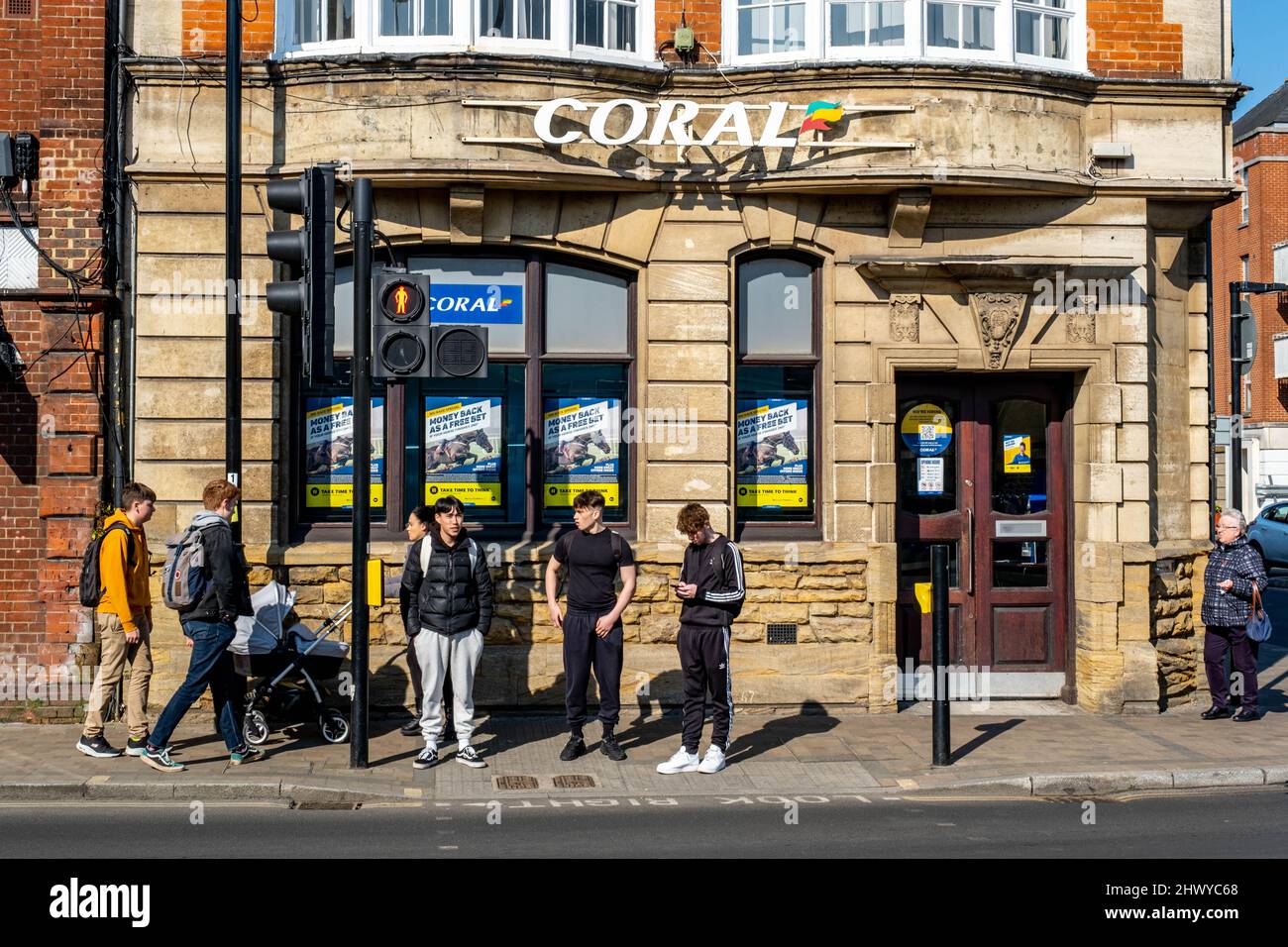 Epsom Surrey London UK, marzo 8 2022, ingresso al Coral Bookmakers Betting Shop con gruppo di ragazzi all'esterno Foto Stock