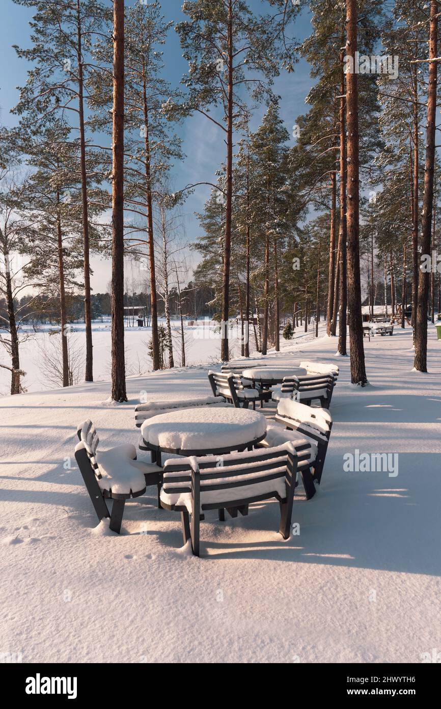 Tavolo da picnic vicino al lago sotto la neve in inverno Foto Stock