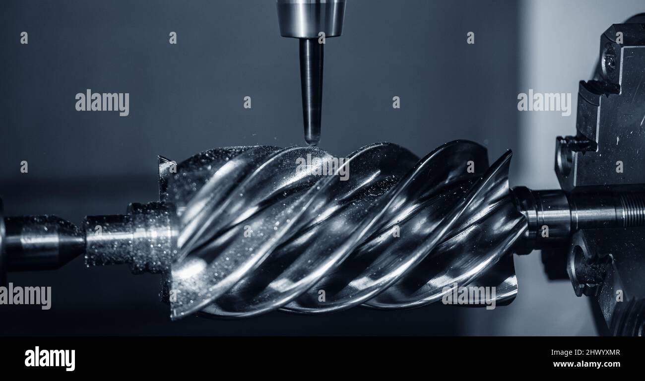 La fresatrice CNC industriale lavora la parte di vite senza fine in acciaio con trucioli metallici. Foto Stock