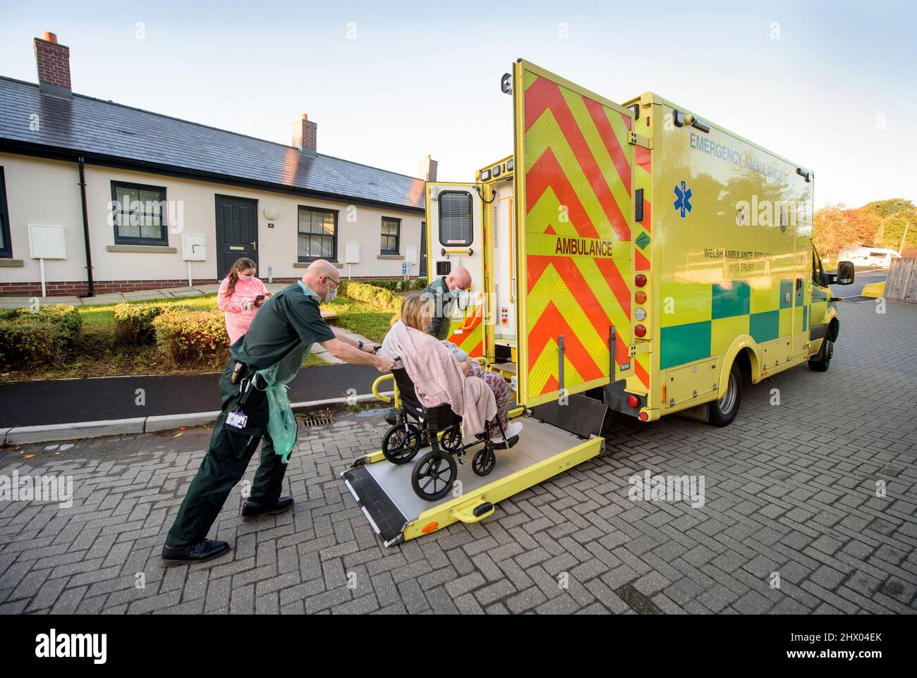 I paramedici spostano un paziente nella loro ambulanza dopo l'esame del paziente nella loro sede vicino Pontypool, S. Galles Regno Unito Foto Stock
