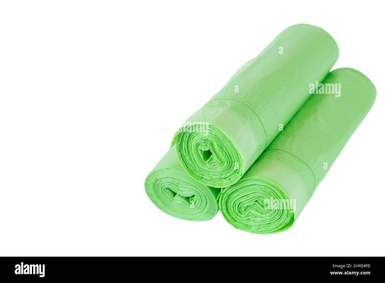 Rotoli verdi di sacchi di rifiuti isolati su sfondo bianco con spazio di copia Foto Stock