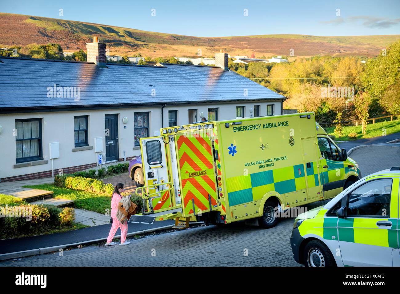 I paramedici spostano un paziente nella loro ambulanza dopo l'esame del paziente nella loro sede vicino Pontypool, S. Galles Regno Unito Foto Stock