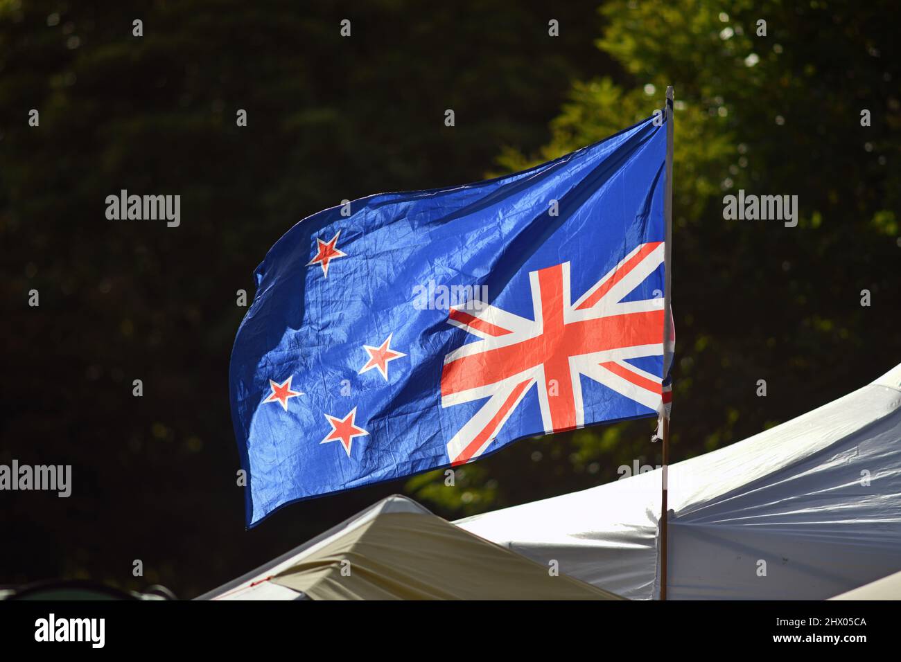 Christchurch, Nuova Zelanda, 22 febbraio 2021: Bandiera invertita vola alla protesta del mandato di Cranmer Square a Christchurch. Gli attivisti hanno piantato tende e occupato la piazza in modo pacifico per diverse settimane. Foto Stock