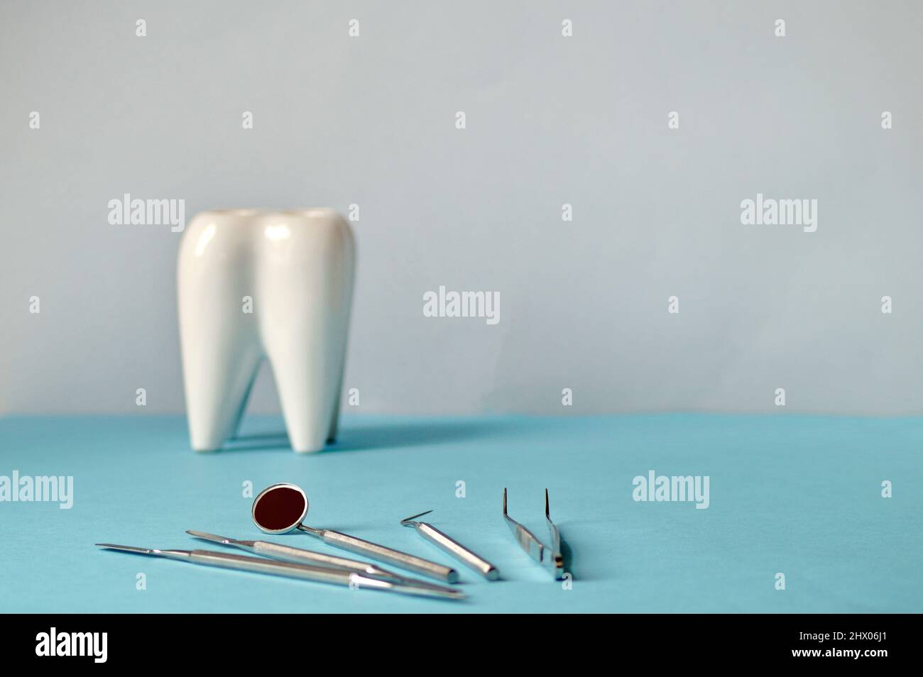 sul tavolo di fronte ad un bel dente bianco giacciono gli strumenti dentistici del dentista. L'immagine è orizzontale Foto Stock