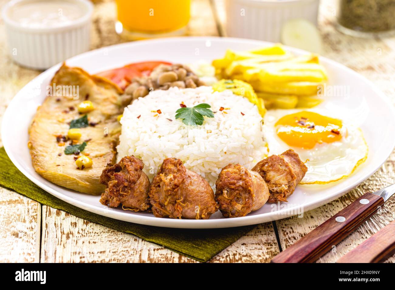 Piatto con tipico pasto brasiliano, salsiccia e pollo fritto, riso con fagioli e insalata, farofa e uova fritte Foto Stock