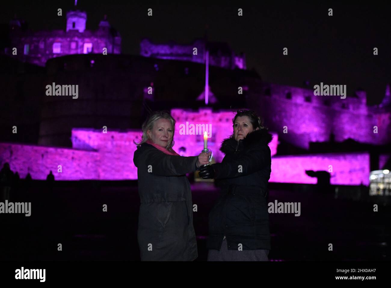 Edimburgo, Scozia, Regno Unito. 8th Mar 2022. NELLA FOTO: Mentre l'oscurità si riduce ai diritti delle donne in Scozia, una protesta silenziosa condotta dal gruppo ForWomen Scotland, un gruppo di donne provenienti da tutta la Scozia che lavora per proteggere e rafforzare i diritti delle donne e dei bambini, vista sul Royal Mile di Edimburgo fuori dal pozzo delle streghe, Protestando silenziosamente per commemorare quelle sorelle cadute che sono state davanti a noi nelle ore di chiusura della Giornata Internazionale della Donna. #ScottishWitches #WomenWontWheesht Credit: Colin Fisher/Alamy Live News Foto Stock