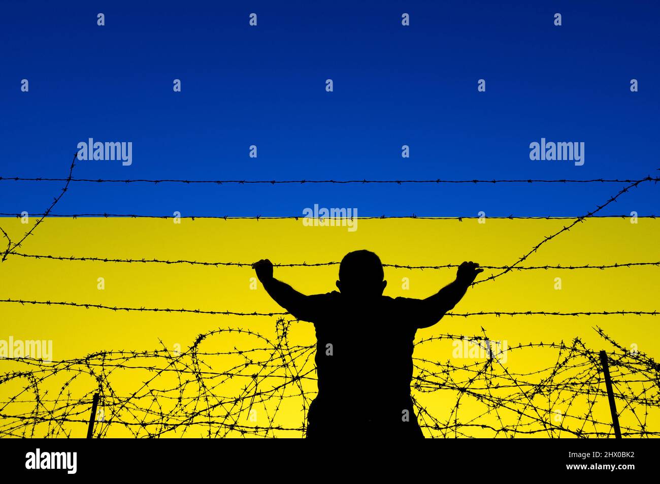 Vista posteriore dell'uomo alla recinzione di frontiera con bandiera dell'Ucraina. Immigrazione britannica, politica dei visti, Ucraina, Russia conflitto rifugiati, Brexit, Confine UE... concetto Foto Stock