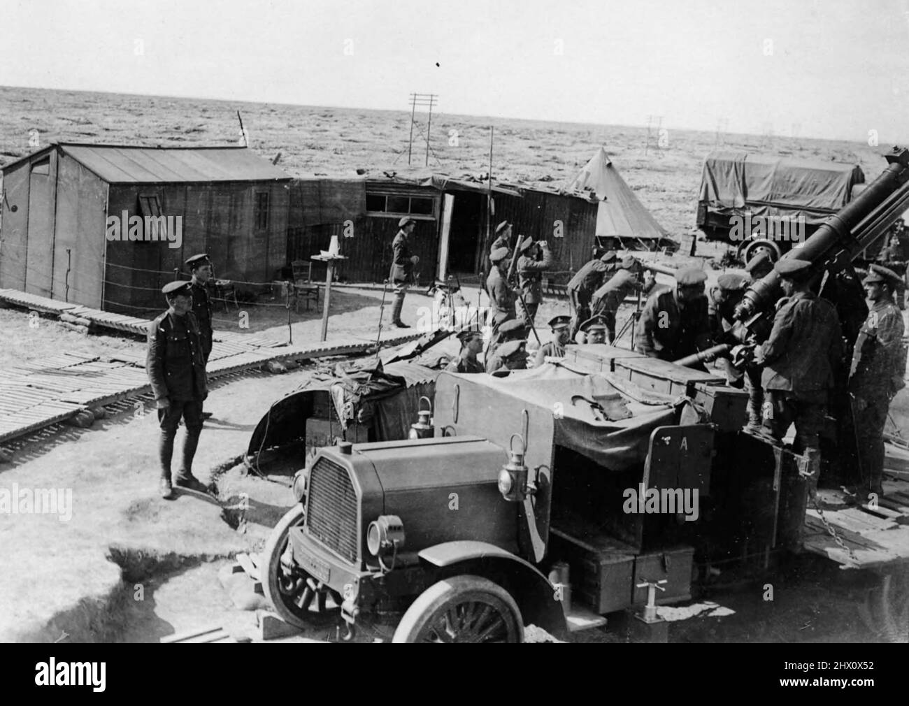 Un equipaggio antiaereo dell'esercito britannico che carica la sua pistola che si trova tra i veicoli di trasporto e accanto al campo di equipaggio a Boyelles, Francia. Foto Stock