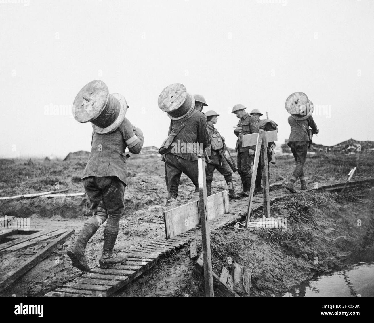 Royal Engineers che prende tamburi di filo telefonico lungo un percorso di duckboard fino al fronte tra Pilckem e Langemarck, 10 ottobre 1917 durante la battaglia di Poelcappelle. Foto Stock