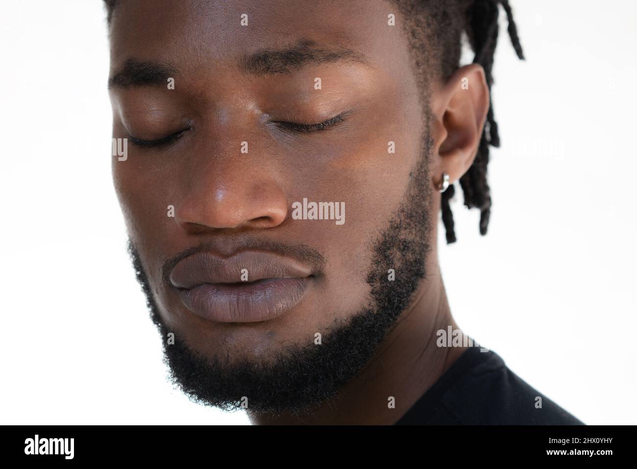 Un ritratto closeup di un uomo afroamericano con gli occhi chiusi Foto Stock