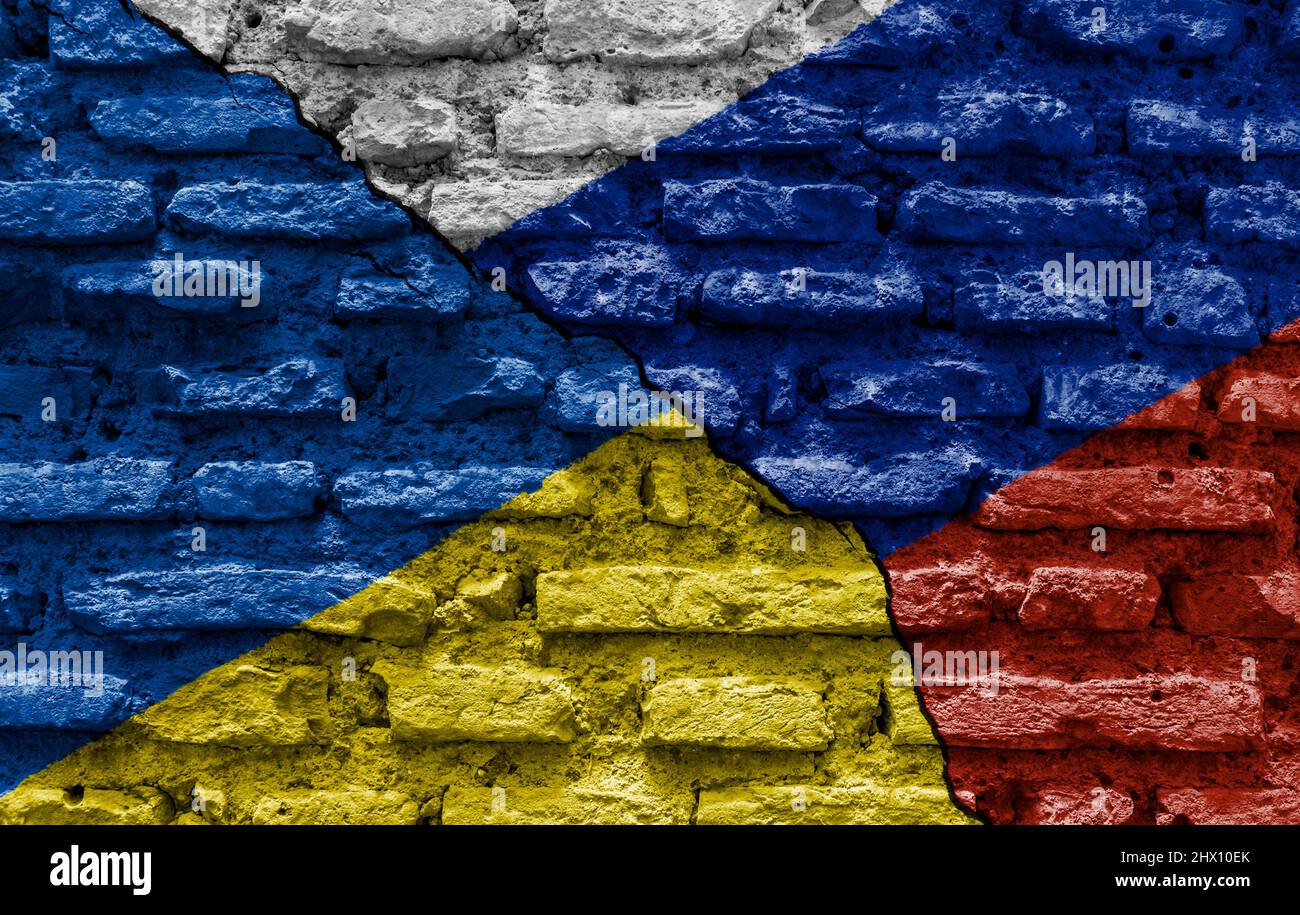 Le bandiere di Ucraina e Russia dipinse su un muro rovinato e diviso da una spaccatura diagonale. Relazioni diplomatiche internazionali. Foto Stock