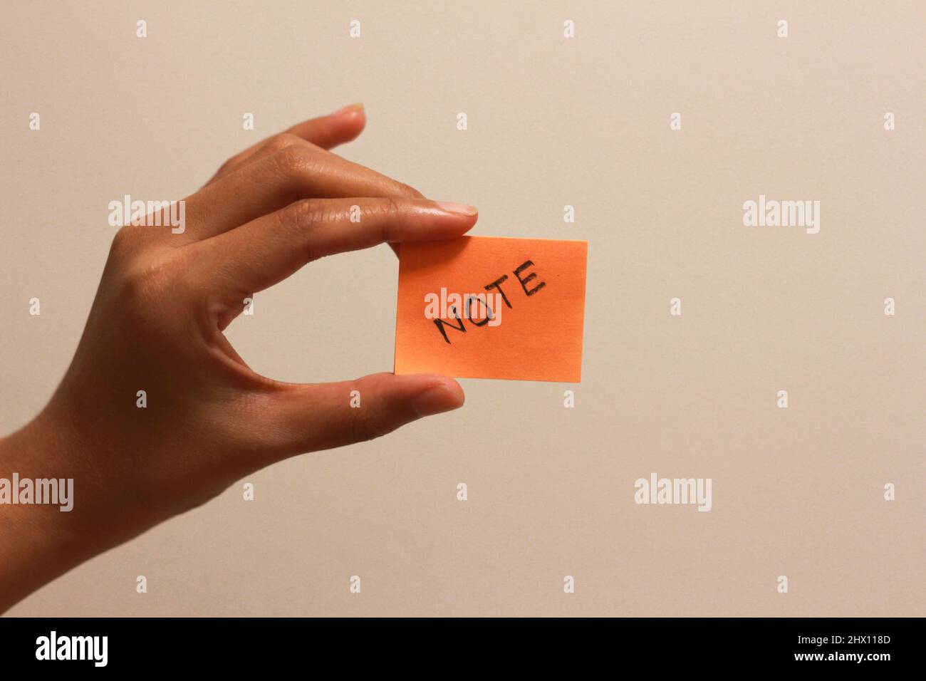 tenere la nota adesiva a mano su sfondo bianco Foto Stock