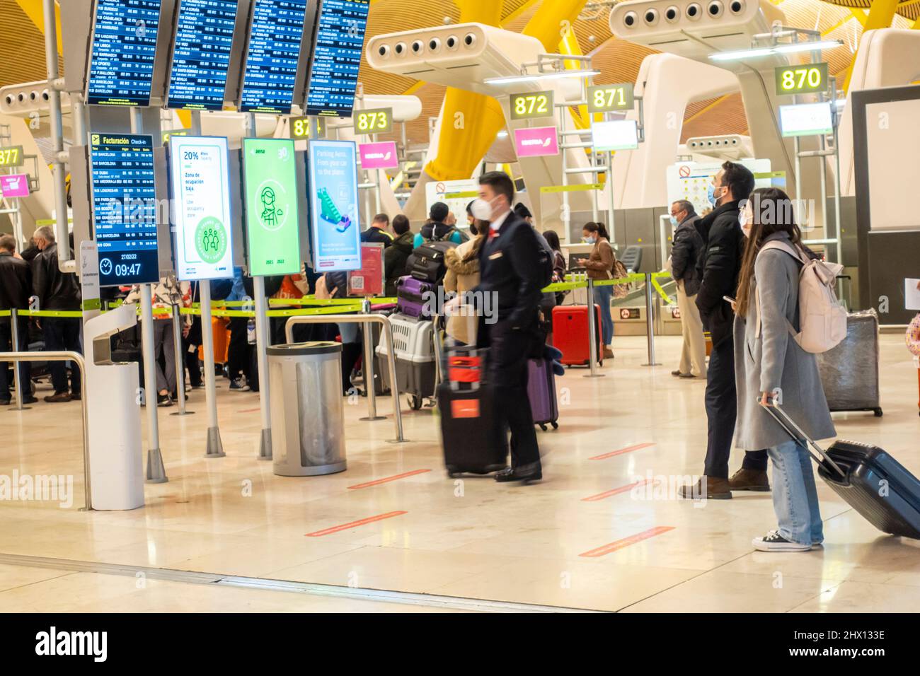 Passeggeri con bagaglio davanti alle informazioni di partenza, prima della zona di controllo di sicurezza, aeroporto Madrid-Barajas, MAD, Spagna Foto Stock
