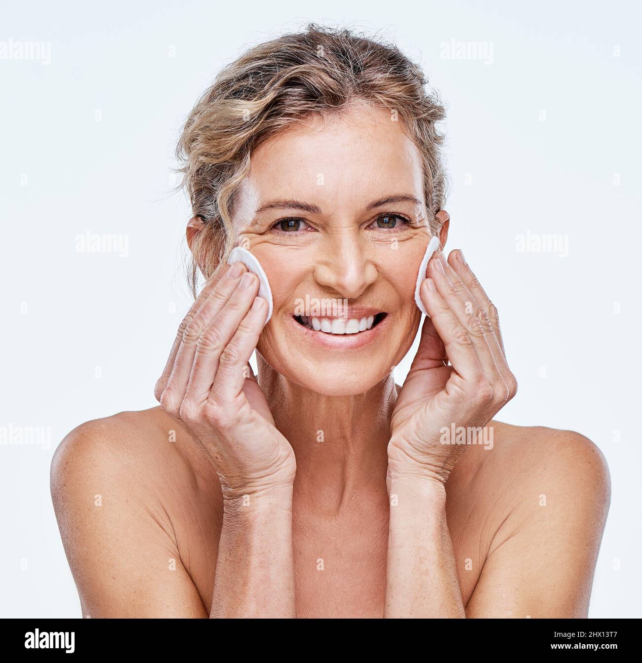 Ho alcune punte thatll aiutano prendere gli anni fuori. Colpo di una donna matura che tiene le cialde di cotone contro il suo viso. Foto Stock