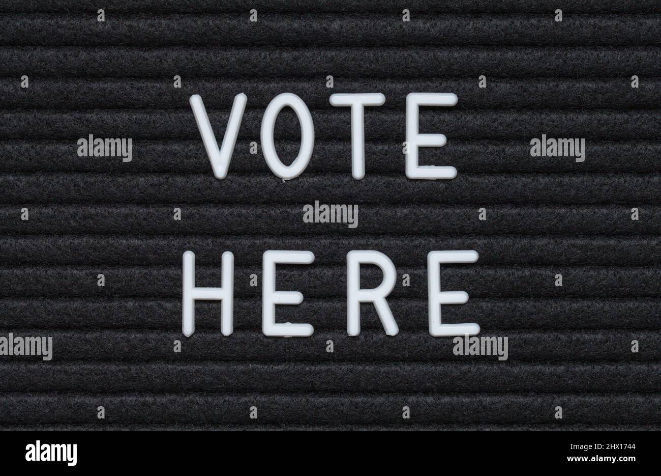 Vota qui Black Felt Letter Board Sign. Foto Stock