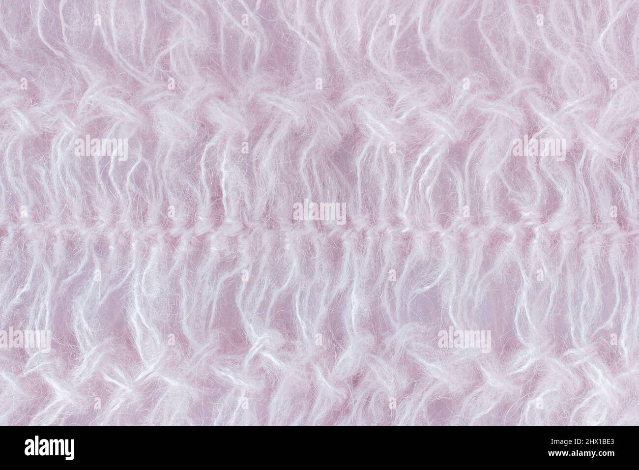 Tessuto a maglia aperto in lana di capra Angora (mohair) di colore rosa. Esempio di lavorazione a maglia su forchetta, fatta a mano. Sfondo, trama. Foto Stock