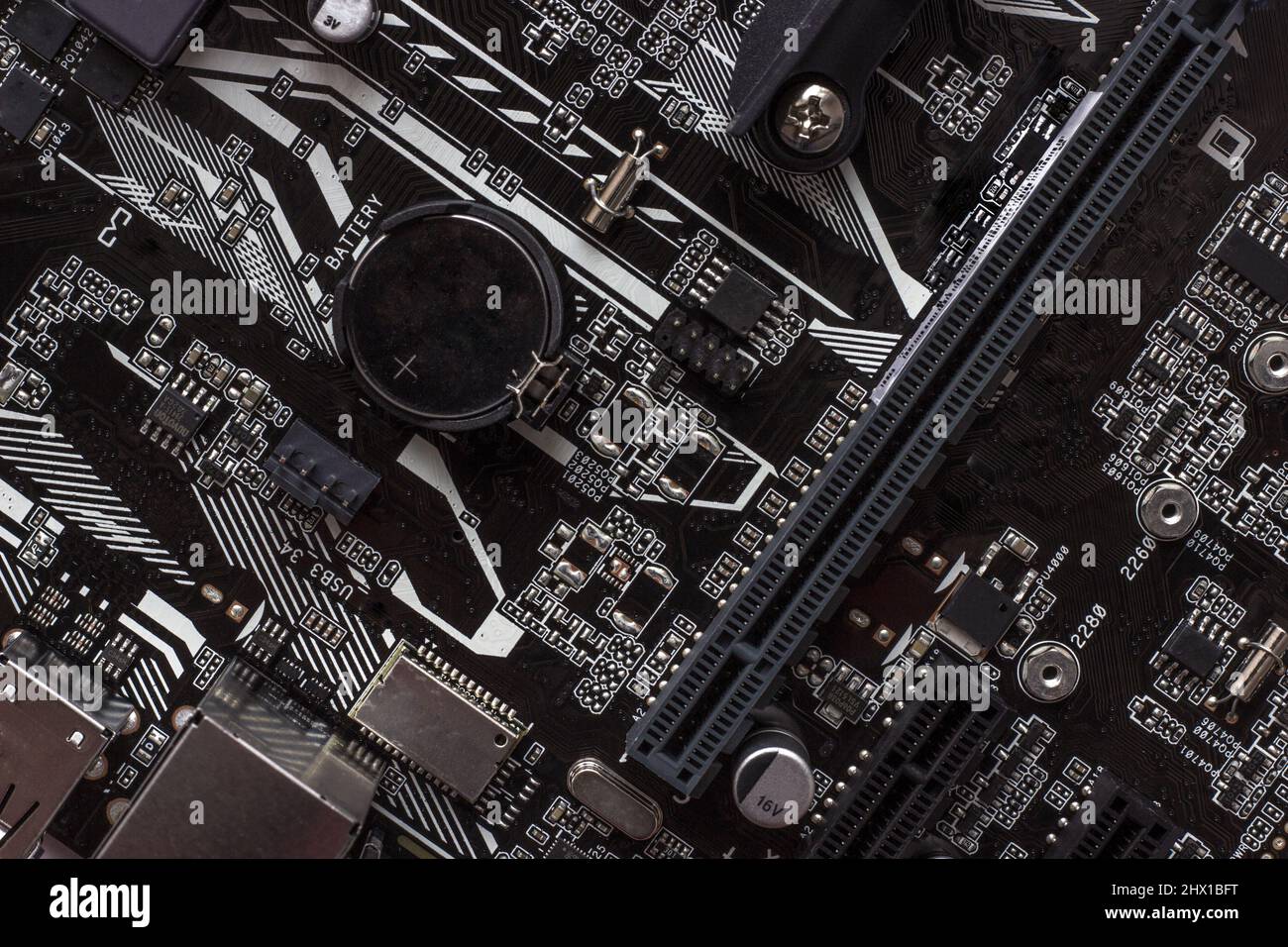 Frammentare il microcircuito della scheda madre o della scheda madre con lo slot e la batteria come sfondo . La scheda a circuito stampato è la base per la costruzione di un computer Foto Stock