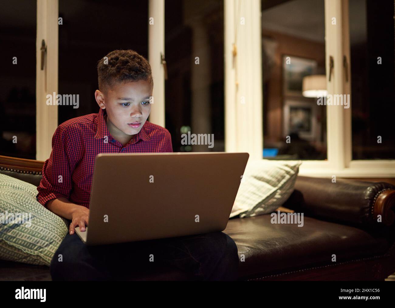 Troppa tecnologia troppo tardi. Girato di un ragazzo usando un portatile oltre il suo tempo di dormire a casa. Foto Stock