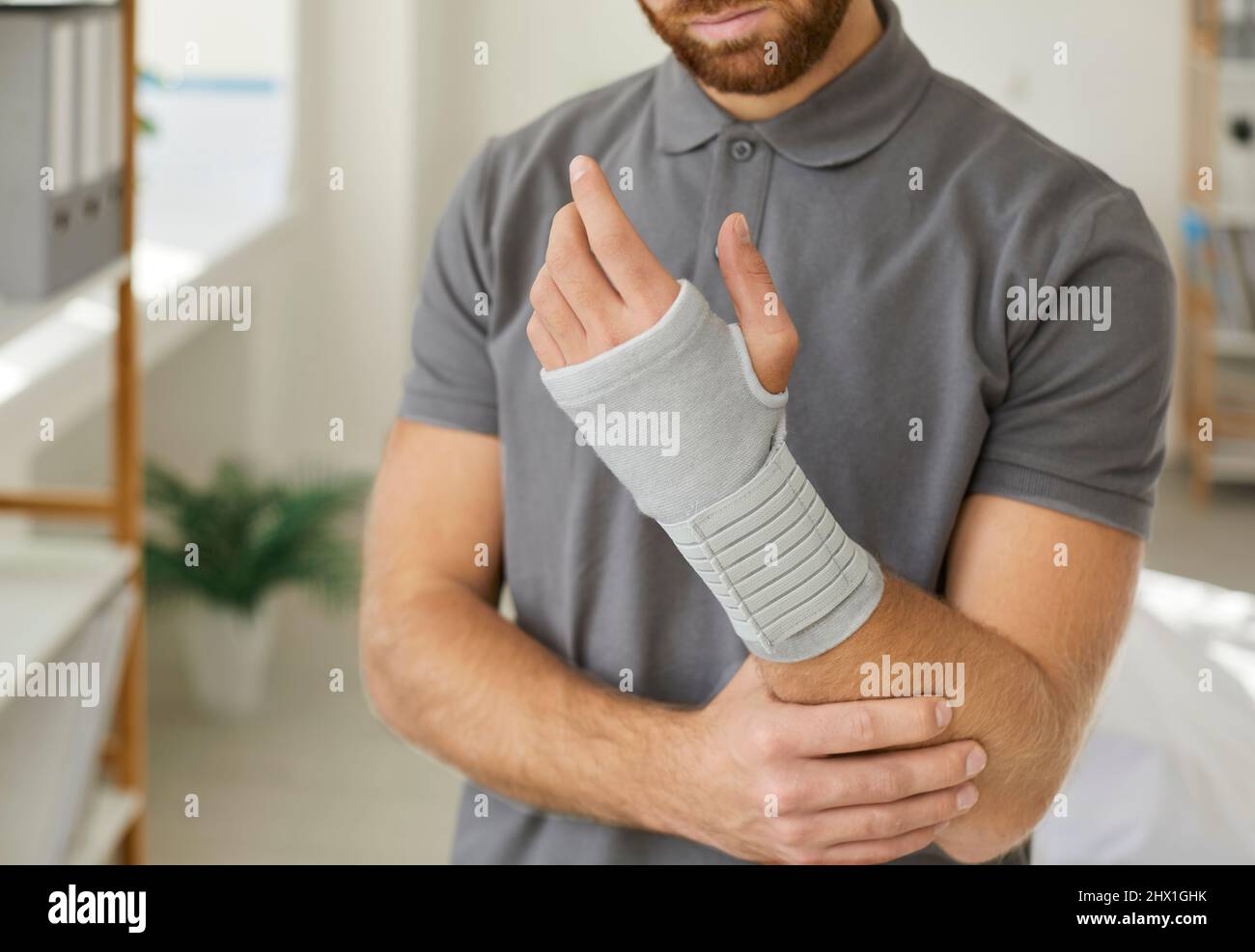 Uomo malsano con mano rotta indossare bendaggio Foto Stock