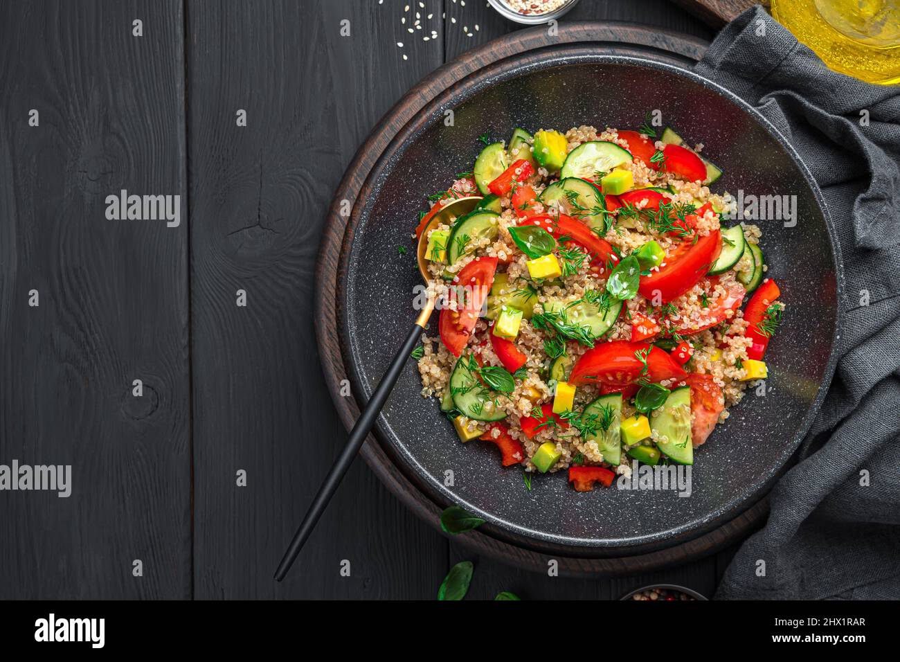 Insalata sana con quinoa, verdure ed erbe fresche su sfondo nero. Insalata vegetariana. Foto Stock