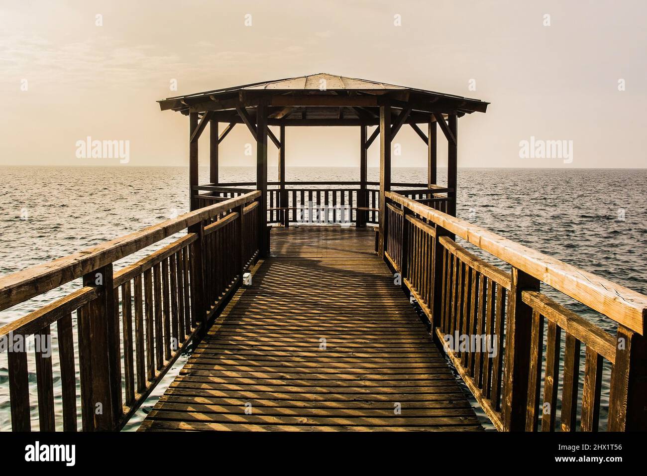 Molo coperto di legno sul lungomare della città di Garda sulla sponda orientale del lago di Garda, provincia di Verona, Veneto, nord-est Italia Foto Stock