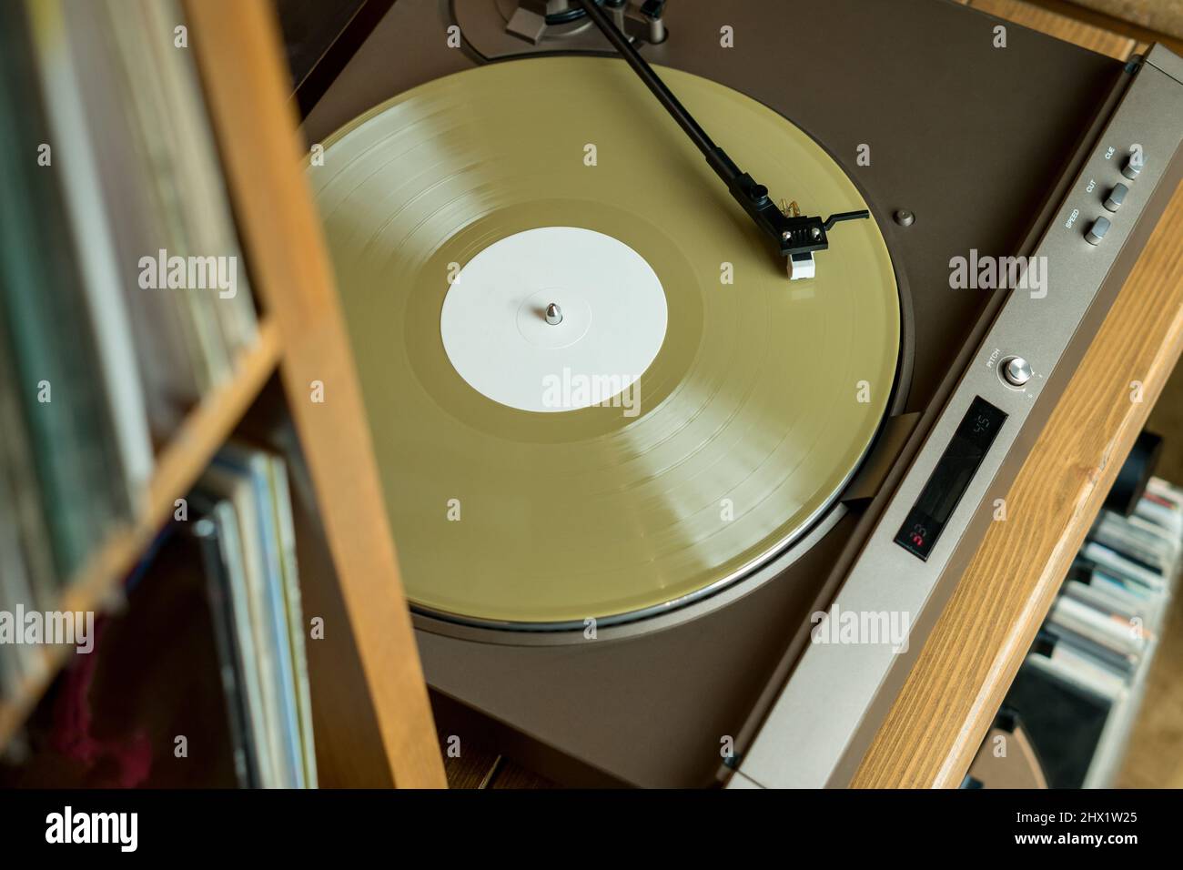 Primo piano di un braccio e di un giradischi che suonano dischi in vinile a colori. Intrattenimento e tendenze musicali Foto Stock