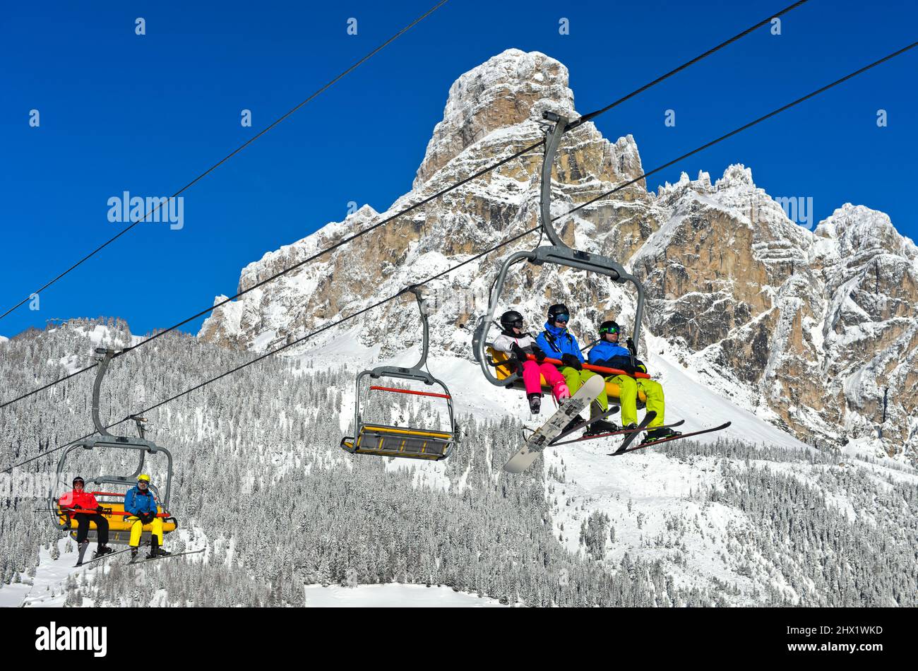 Sciatori in seggiovia nel comprensorio sciistico la Villa, dietro la vetta Sassongher, alta Badia, Dolomiti, Alto Adige, Italia Foto Stock