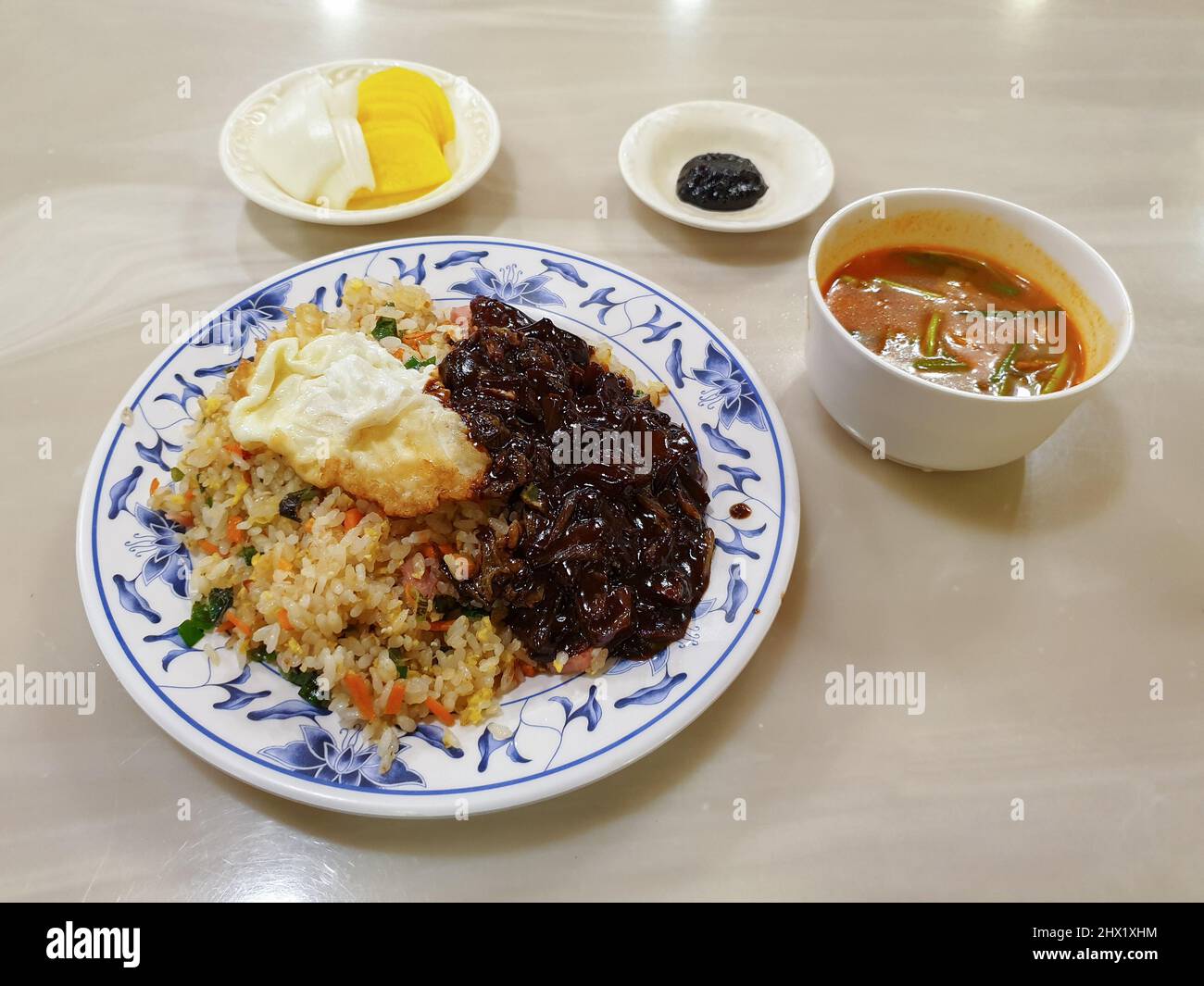 Bokkeumbap, un riso fritto al ristorante cinese in stile coreano. Servito con zuppa di danmuji e jamppong. Foto Stock