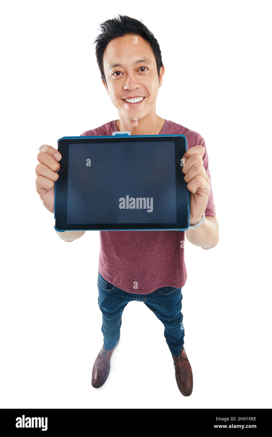 Permettetemi di aiutarvi a vendere questo tablet. Ritratto da studio di un giovane che tiene su un tablet vuoto su uno sfondo bianco. Foto Stock