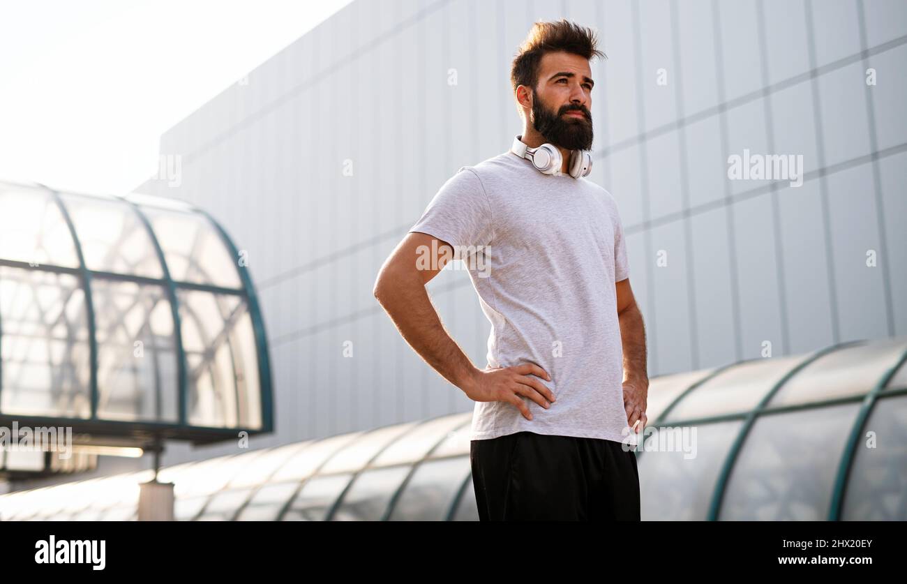 Felice giovane uomo in forma che si esercita e gode di uno stile di vita sano. Concetto di corsa per le persone sportive Foto Stock