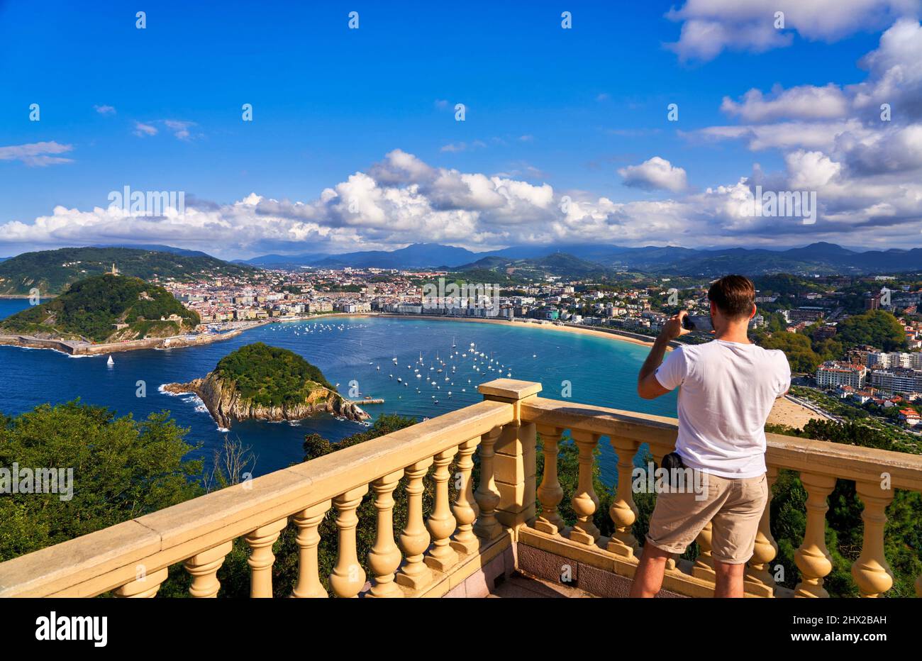Turista fotografando la Baia di Concha dal punto di vista del Monte Igeldo, Donostia, San Sebastian, città cosmopolita di 187.000 abitanti, nota per la sua Foto Stock