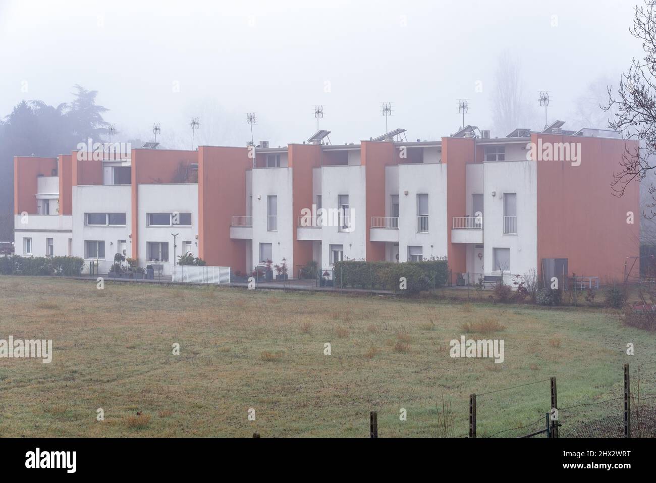 L'esterno delle moderne case a schiera in una mattina d'inverno nebbia Foto Stock
