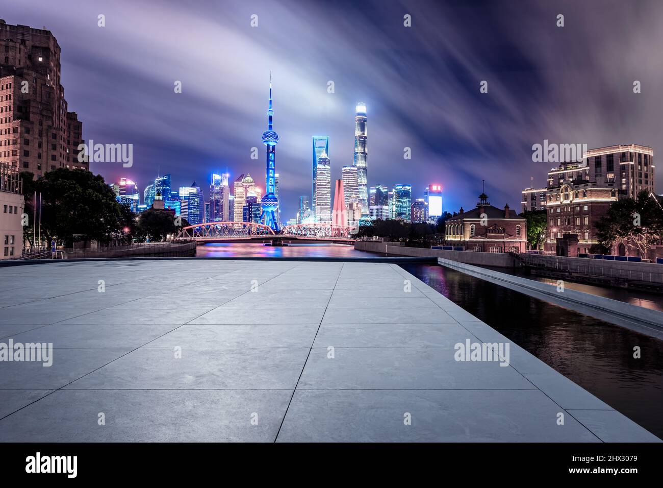 Skyline panoramico e moderni edifici commerciali con pavimento quadrato vuoto a Shanghai di notte, Cina. Strada vuota e paesaggio urbano. Foto Stock