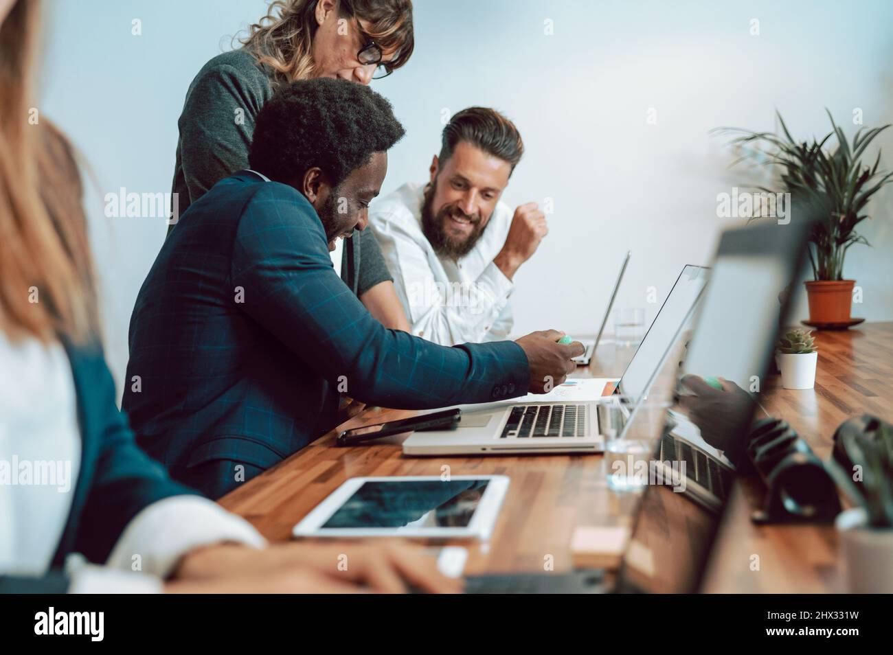 Contenuti diversi colleghi che esaminano i documenti vicino ai notebook Foto Stock