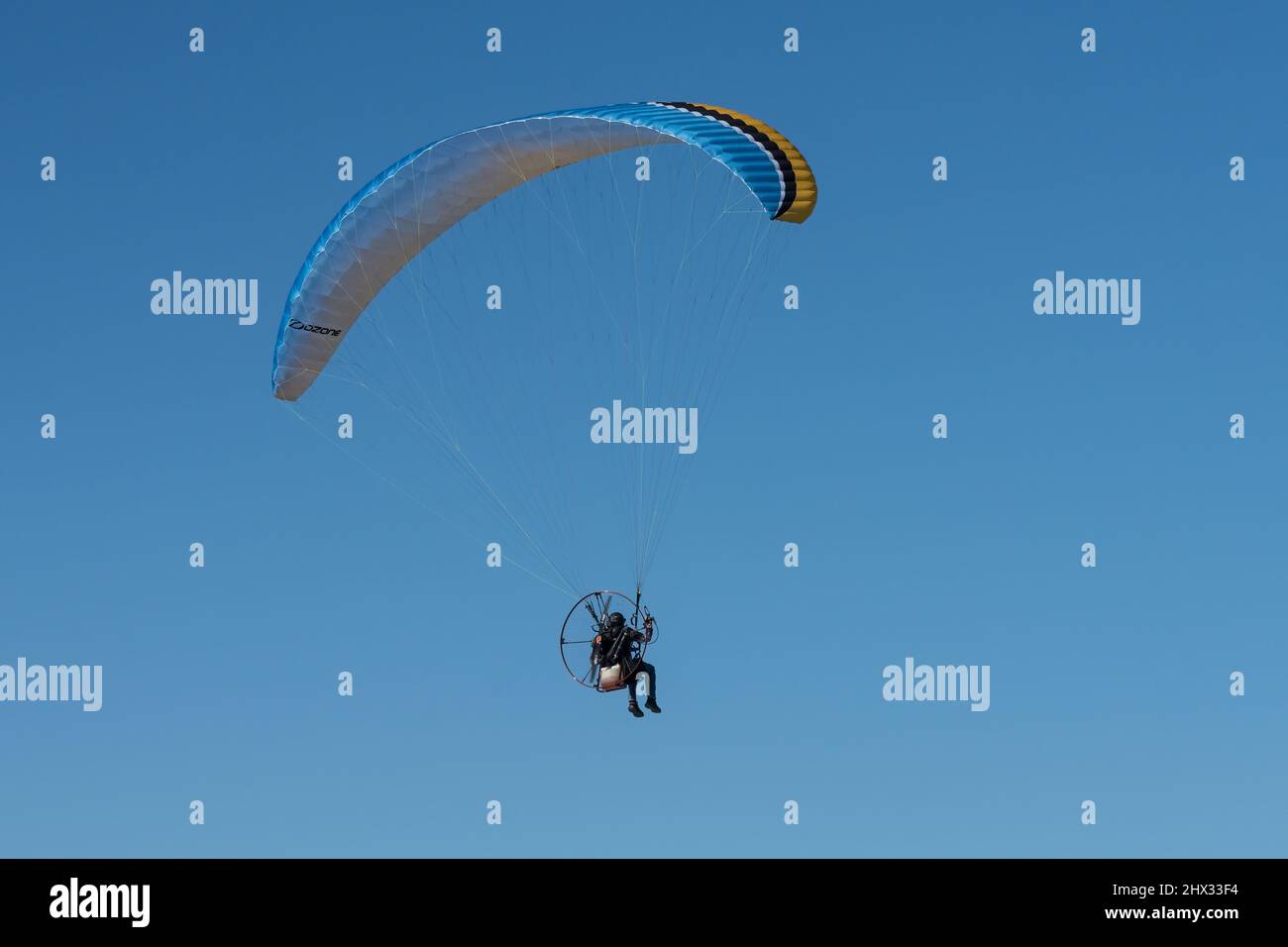 Un parapendio alimentato in aria in inverno su South Padre Island, Texas. Su un parapendio motorizzato, il pilota indossa un motore zaino. Foto Stock