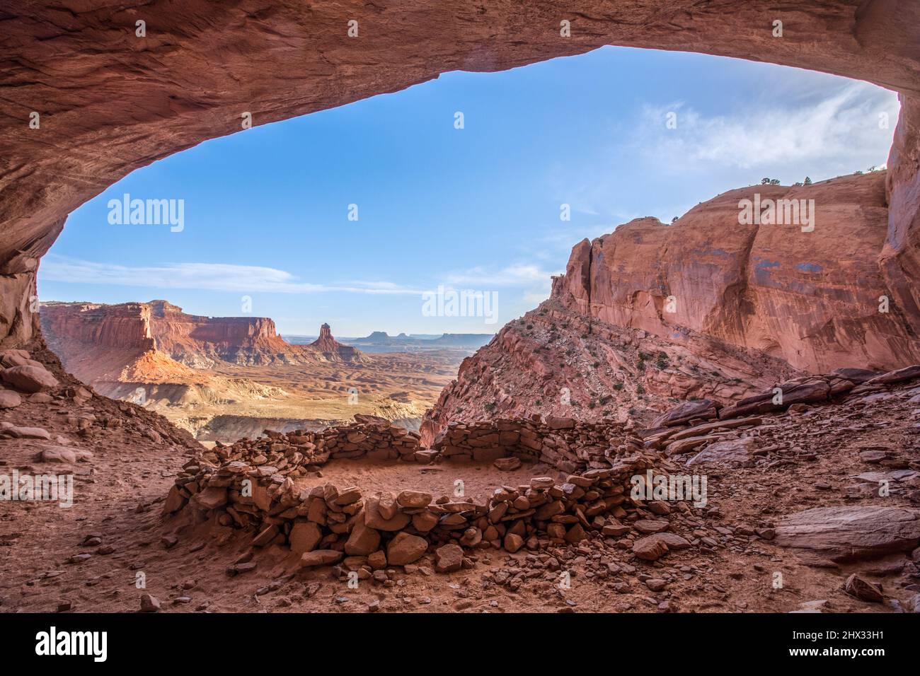 Il False Kiva rovina in un'alcova nel Canyonlands National Park vicino a Moab, Utah. In lontananza si trova la Torre del Candlestick, un monolito di arenaria dell'Ala Foto Stock