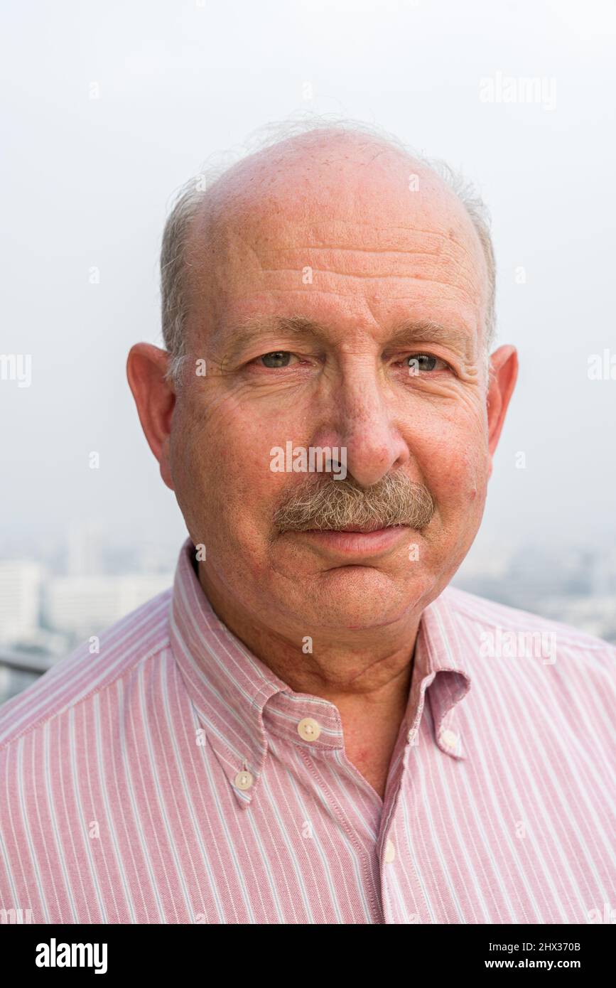 Ritratto di uomo d'affari senior che guarda la macchina fotografica in città sul tetto Foto Stock