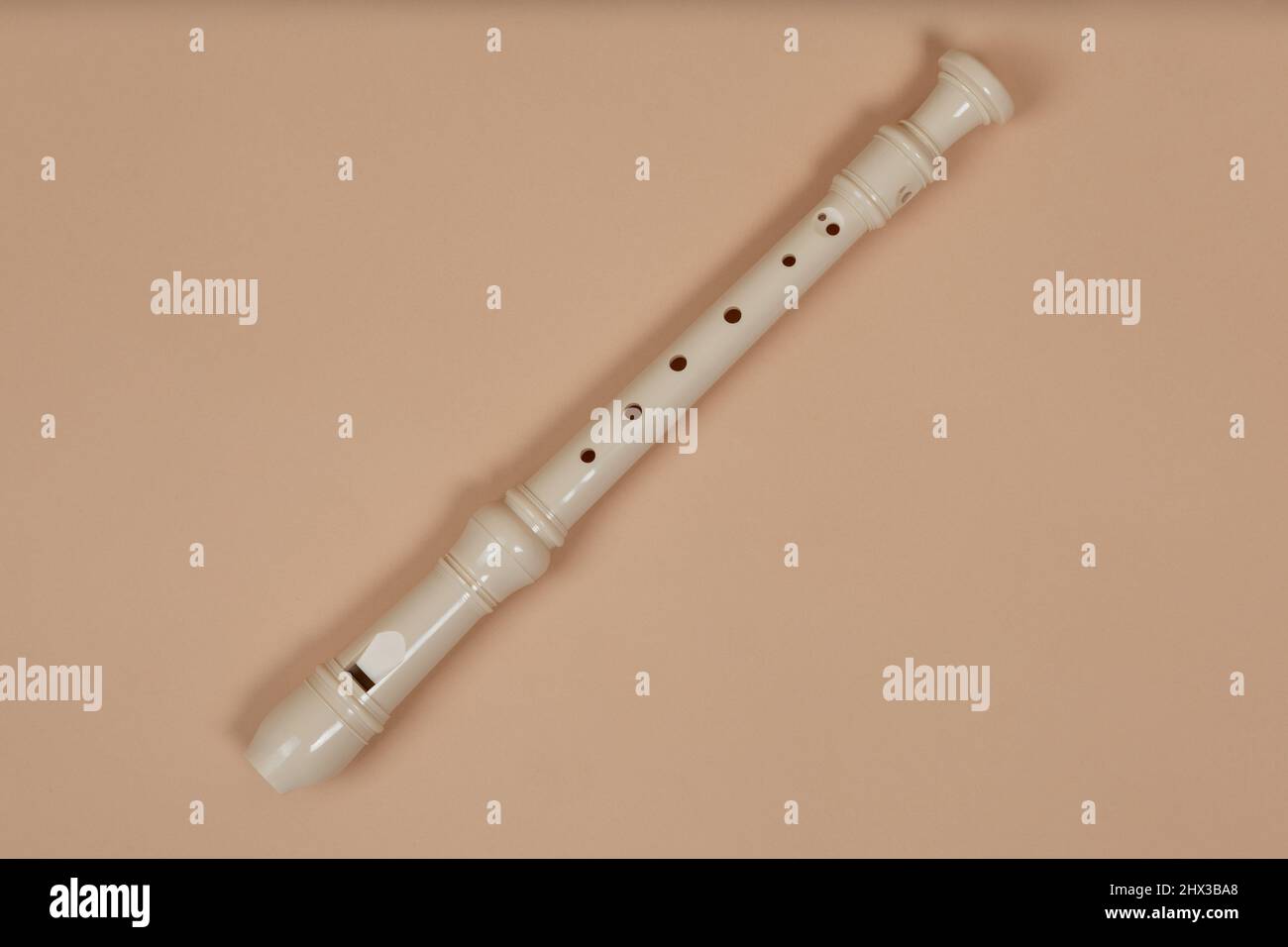 Closeup flauto comune fipple, sfondo beige. Il flauto appartiene a un gruppo di strumenti musicali a vento di legno. Foto Stock