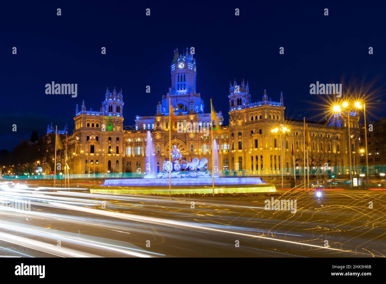 Municipio di Madrid, Spagna illuminato di notte in blu e giallo con una bandiera dell'Ucraina Foto Stock