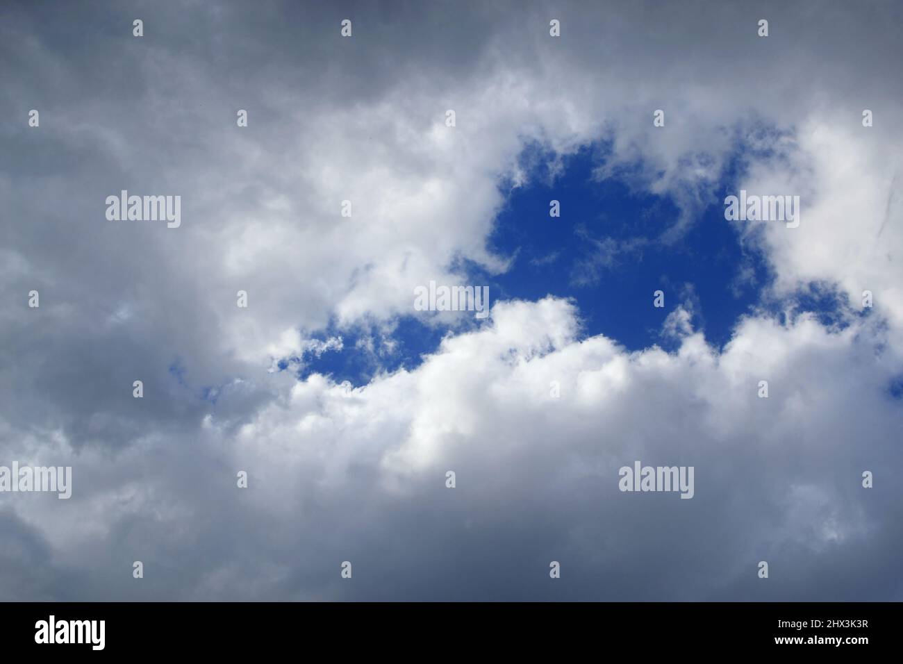 Buco nella nube.glimpse del cielo nelle nuvole. Cielo blu che si infrange attraverso le nuvole. Un frammento di cielo coperto da folte nuvole di pioggia con un barlume Foto Stock
