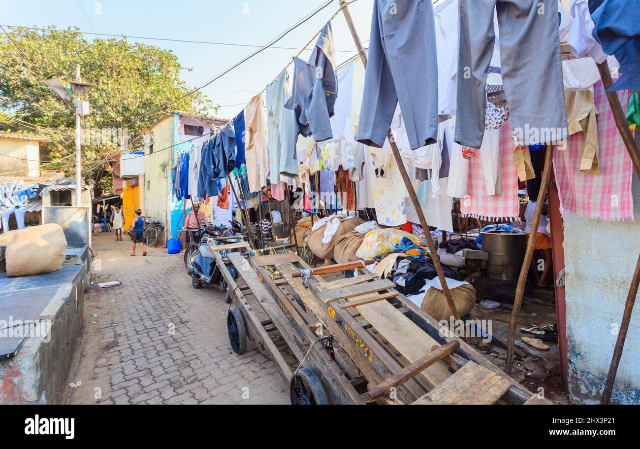 Barroli di legno parcheggiati e vestiti puliti appesi fuori per asciugare al Mahalaxmi Dhobi Ghat, una grande lavanderia all'aperto a Mumbai, India Foto Stock