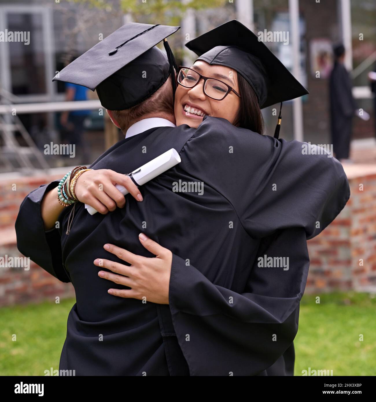 Fa rivivere grandi momenti. Shot di due studenti che abbraccia il giorno della laurea. Foto Stock