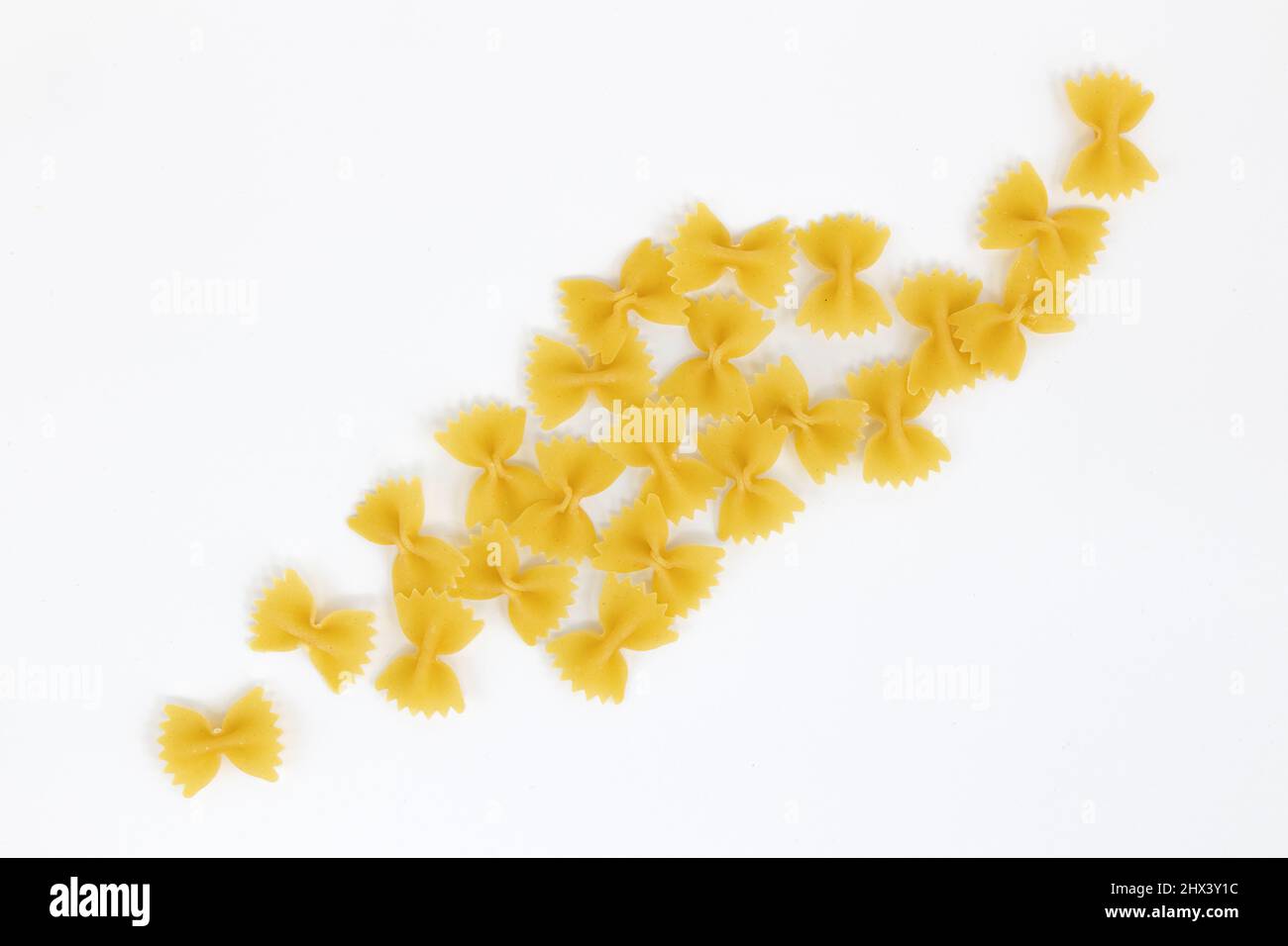 farfalle di pasta cruda su sfondo bianco, vista dall'alto dell'ingrediente della cucina italiana Foto Stock