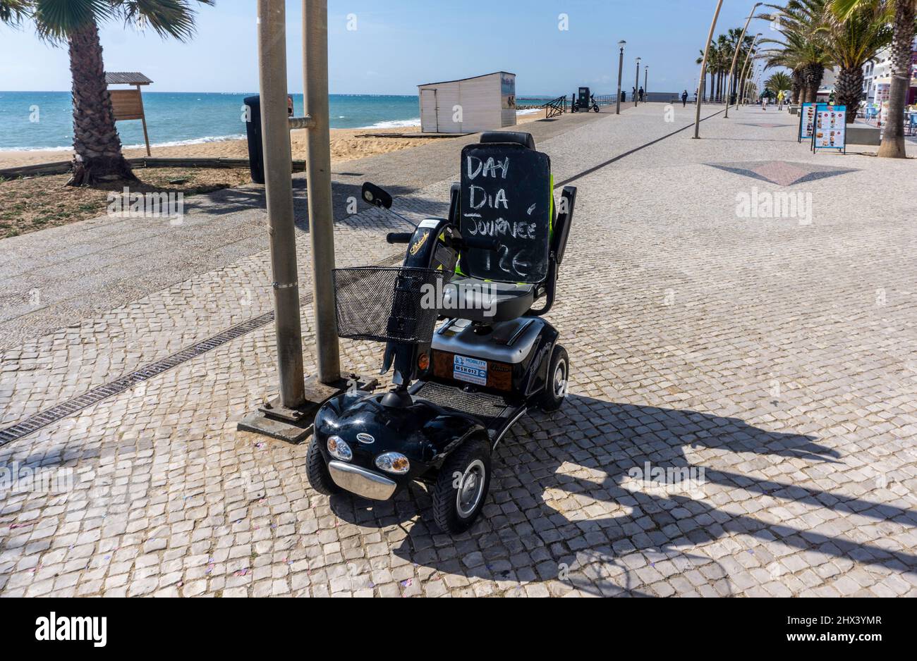 Uno scooter mobile a noleggio sul lungomare di Quarteira, Portogallo. Foto Stock