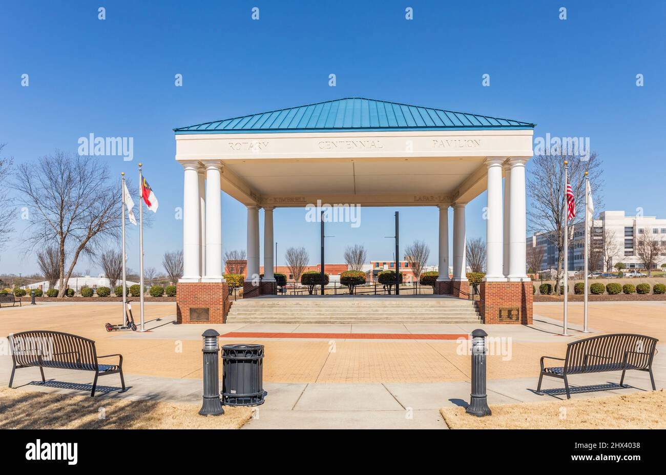 GASTONIA, NC, USA-3 MARZO 2022: Il padiglione del Rotary Centennial, 107 N South St, Gastonia, NC. Vista su padiglioni, bandiere e sedili a panca. Primavera soleggiata Foto Stock