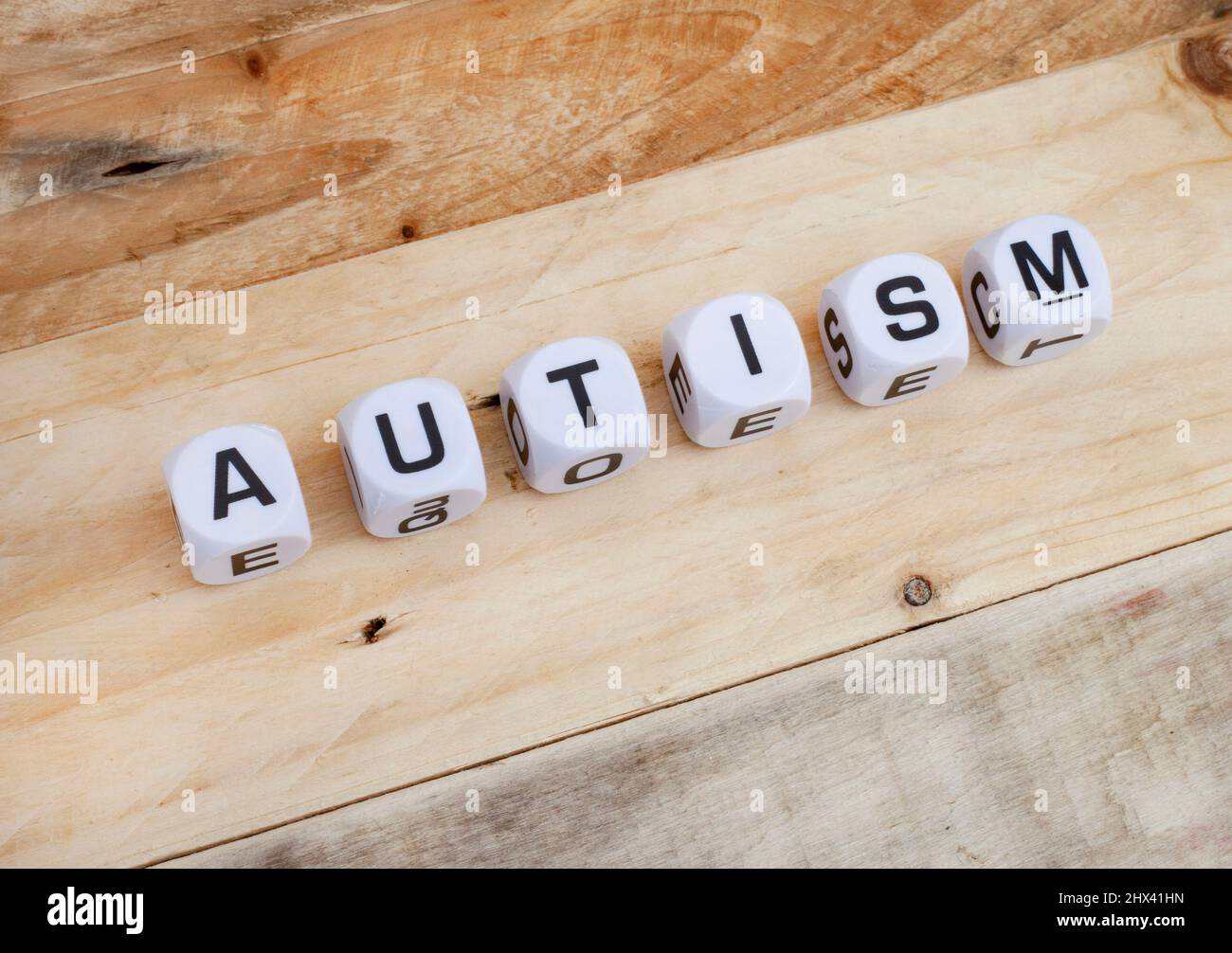 Consapevolezza autismo, autismo scritto in lettere dadi con pezzi di puzzle Foto Stock