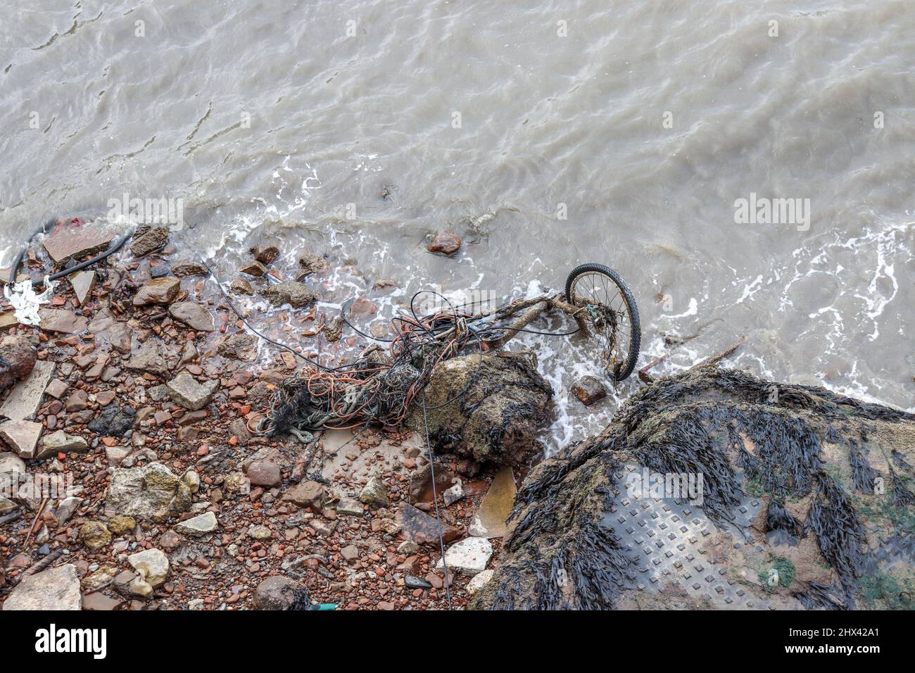 Vecchia bici arrugginita gettata nel fiume Mersey Foto Stock