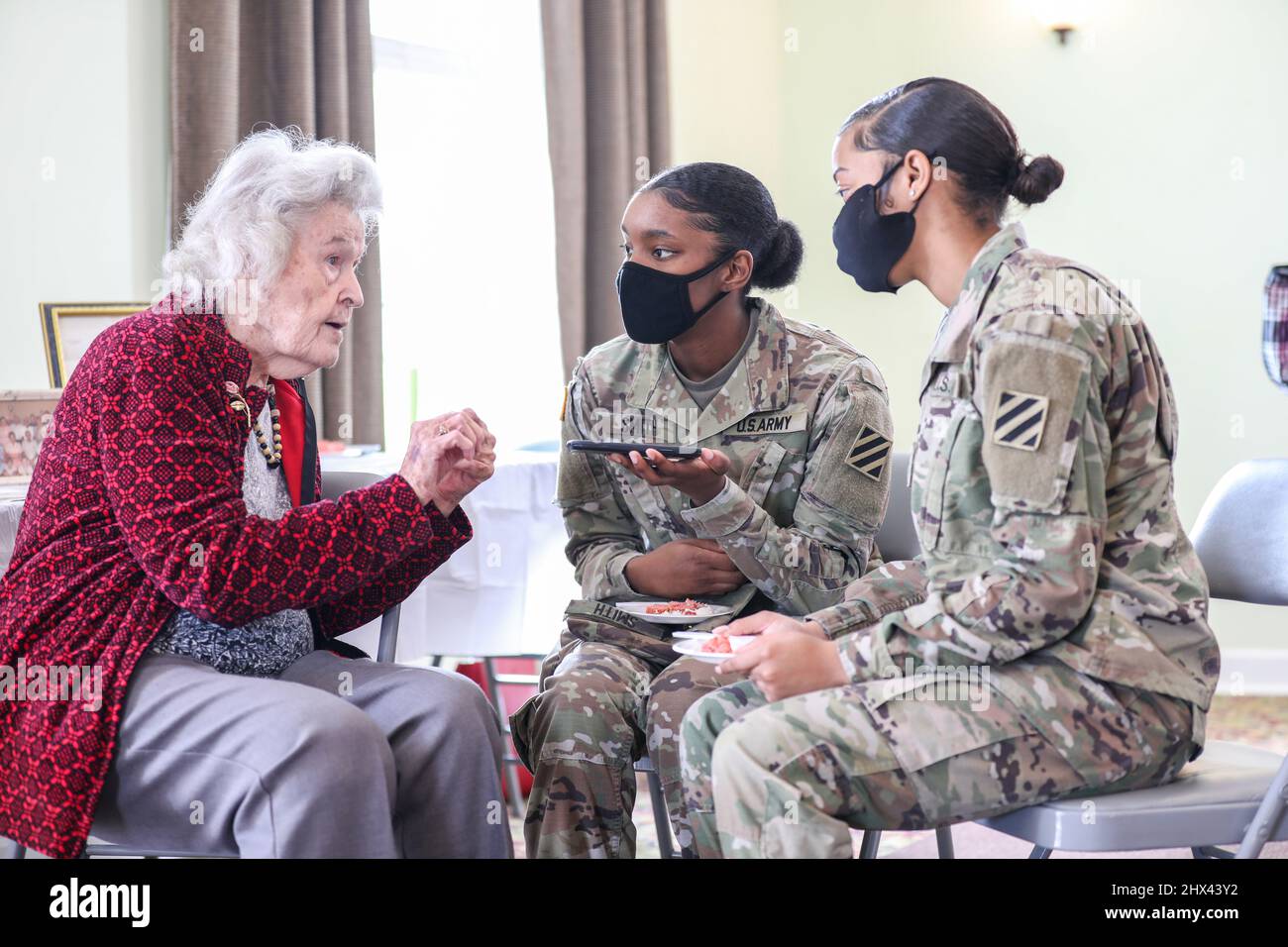 Statesboro, Georgia, Stati Uniti. 27th Feb 2022. Annie Laura Bailey, una delle prime donne in Georgia ad unirsi al corpo ausiliario dell'esercito femminile nel 1943, ha una conversazione con SPC. Dionna Smith (sinistra) e SPC. Ahmyra Hollis (a destra), entrambi i soldati assegnati al quartier generale e al quartier generale Battaglione, 3rd Divisione di fanteria, alla Chiesa Battista Missionaria di Bethel a Statesboro, Georgia, 27 febbraio 2022. US Army 3rd ID soldati hanno celebrato Bailey come parte del mese della storia delle donne, che riconosce i contributi che le donne hanno fatto alla nazione e i risultati specifici che hanno fatto durante il corso o Foto Stock